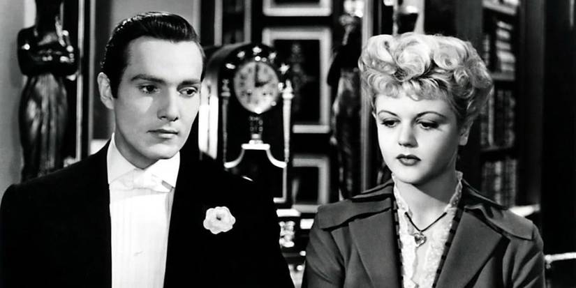 Dorian Grey next to a young woman in front of a grandfather clock in The Picture of Dorian Gray