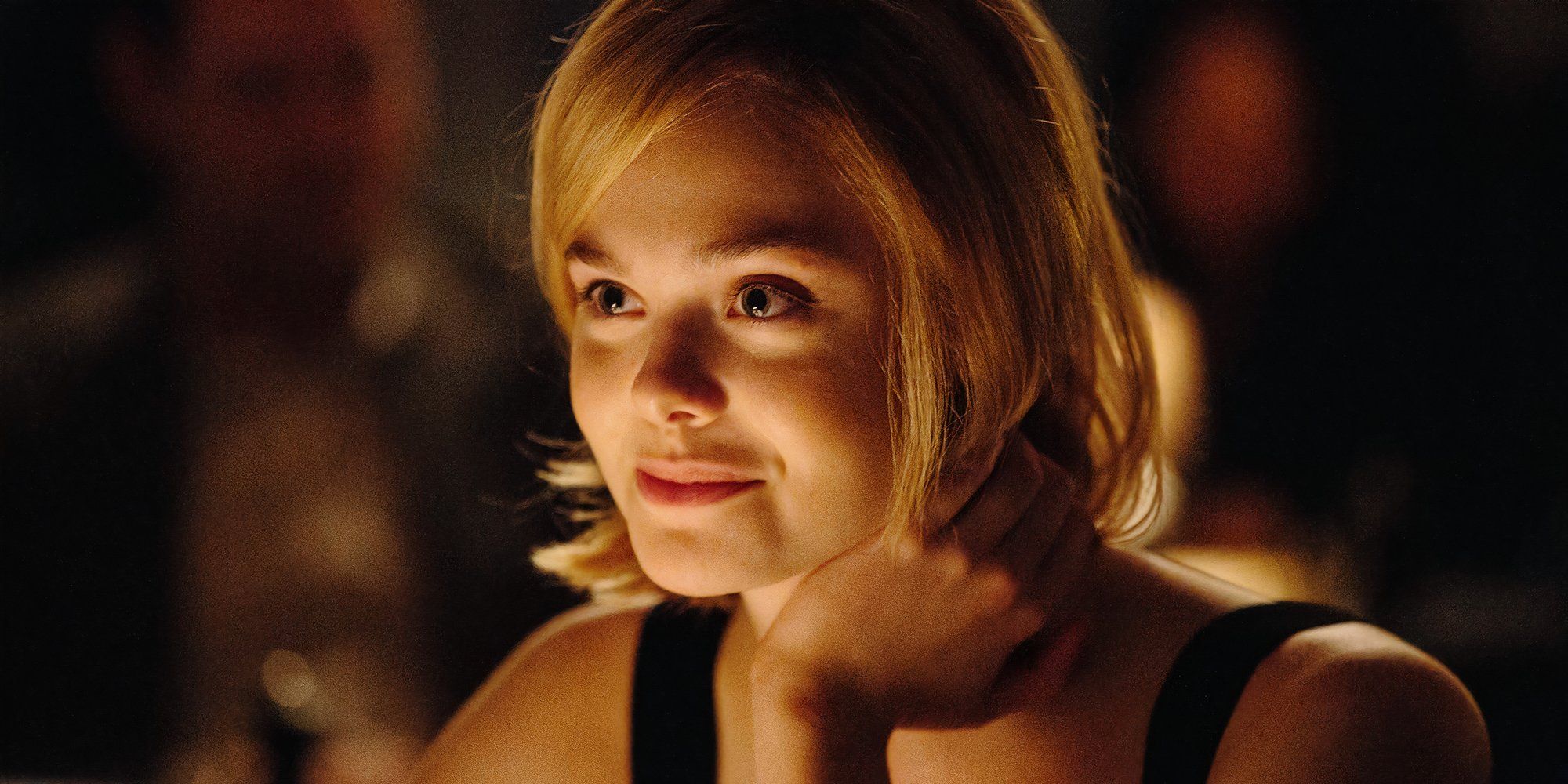 Melody smiling in a darkly-lit room in 'The Vanishing of Sidney Hall' (2017)