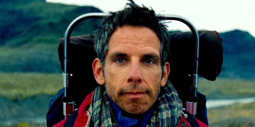 Ben Stiller as Walter Mitty faces the camera with mountains in the background wearing a hiking backpack in The Secret Life of Walter Mitty