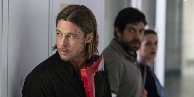 Brad Pitt as Gerry Lane hides with two others while holding an axe in World War Z