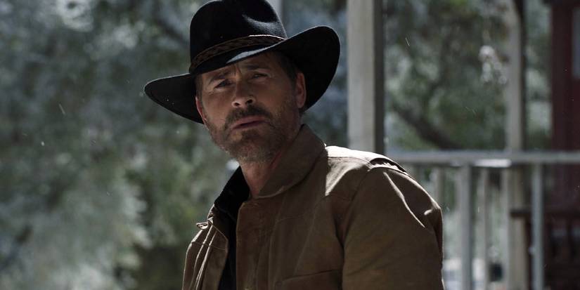 Rob Lowe wears a scruffy beard and looks into the distance wearing a cowboy hat in 9-1-1: Lone Star.