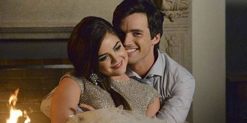 Aria in Ezra's arms in front of the fireplace on Pretty Little Liars