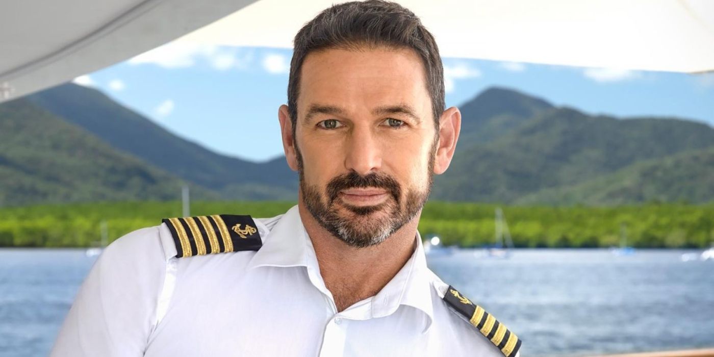 Captain Jason Chambers' in uniform on a boat on water in a promo shot for 'Below Deck Down Under.'