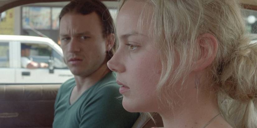 Heath Ledger looks at Abbie Cornish as they sit in a vehicle in 'Candy' (2006).