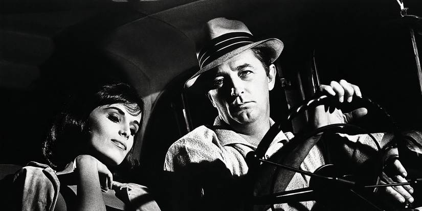 Robert Mitchum driving a car with a girl beside him in Cape Fear