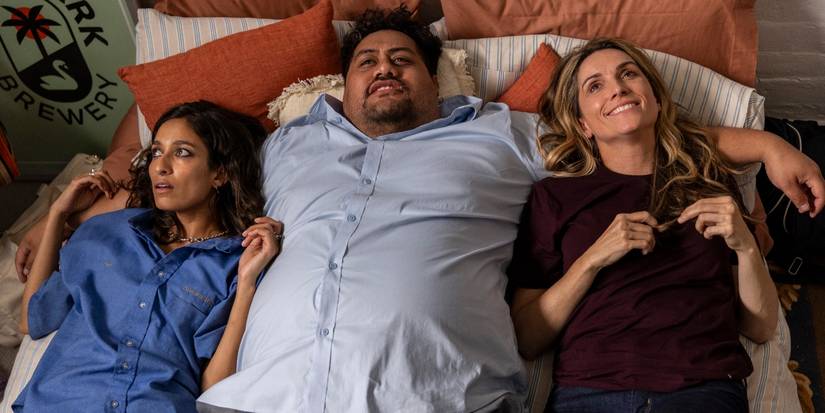 Emma Harvie, Michael Logo, and Genevieve Hegney in bed in Colin From Accounts Season 2