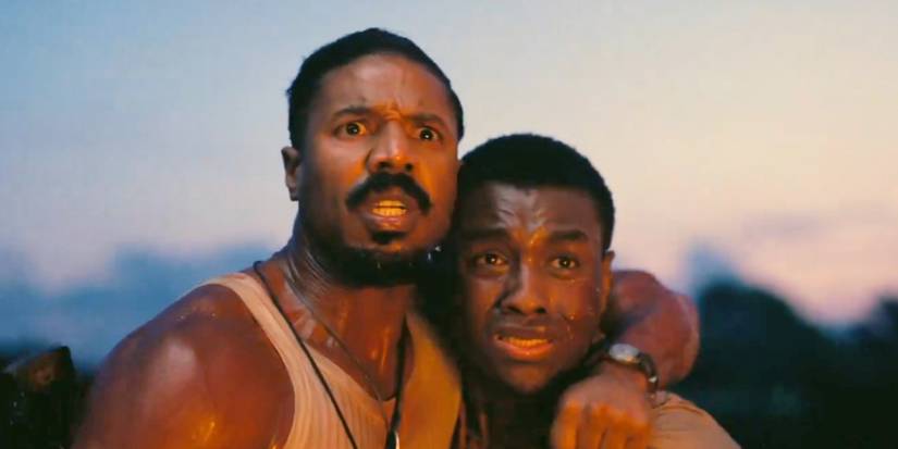 Smoke and Sammie, played by actors Michael B. Jordan and Miles Caton, look at something, terrified, in Sinners.