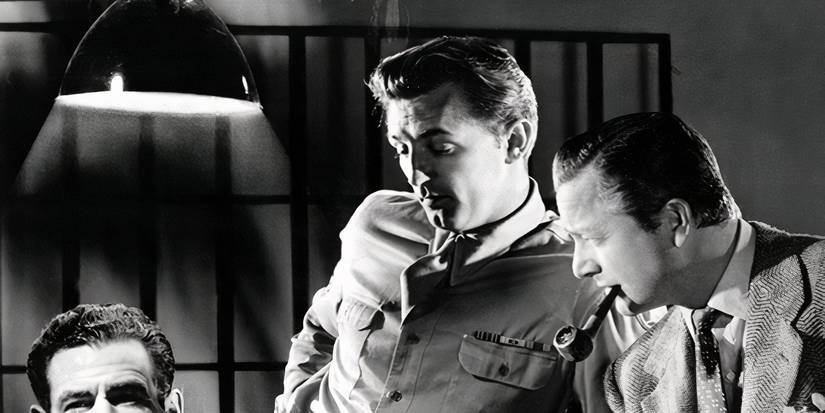 Tow soldiers looking down at something in Crossfire (1947)