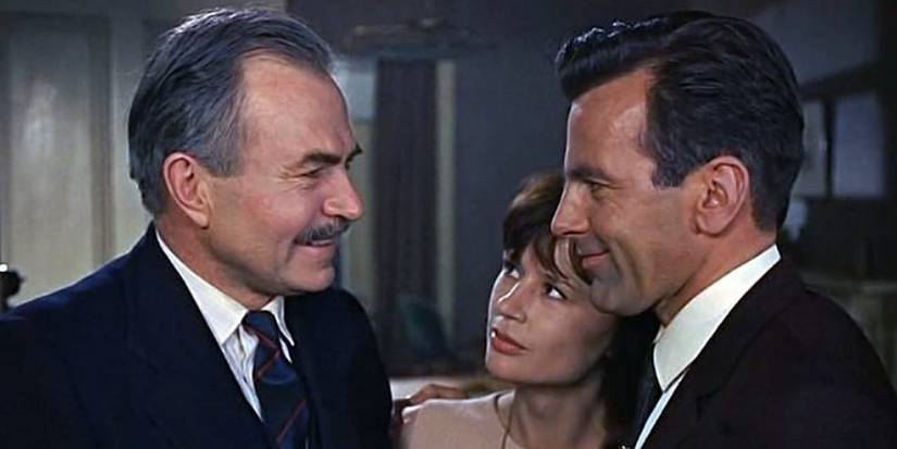 Two men and a woman talking and smiling at each other in The Deadly Affair