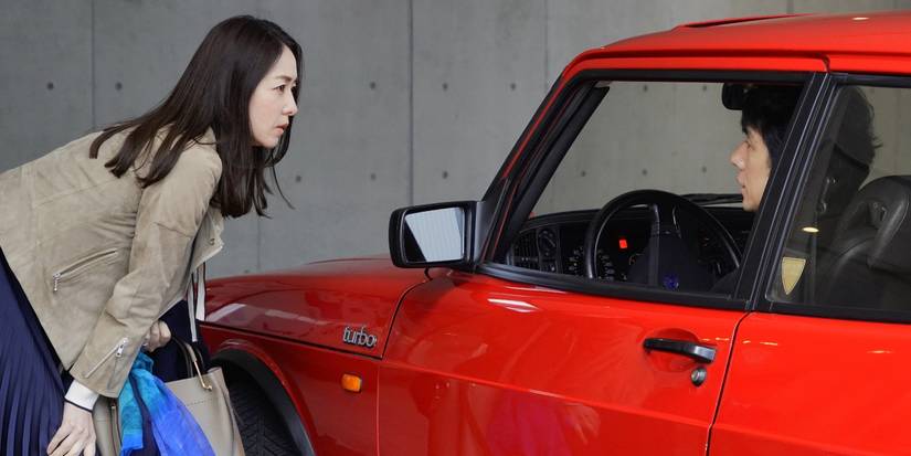 Hidetoshi Nishijima as Yūsuke Kafuku and Tōko Miura as Misaki Watari talking to eachother through the car window in Drive My Car