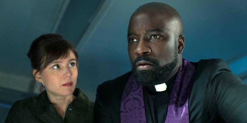 Katja Herbers as Kristen looking to the left at Mike Colter in his priest attire in Season 4 of Evil.