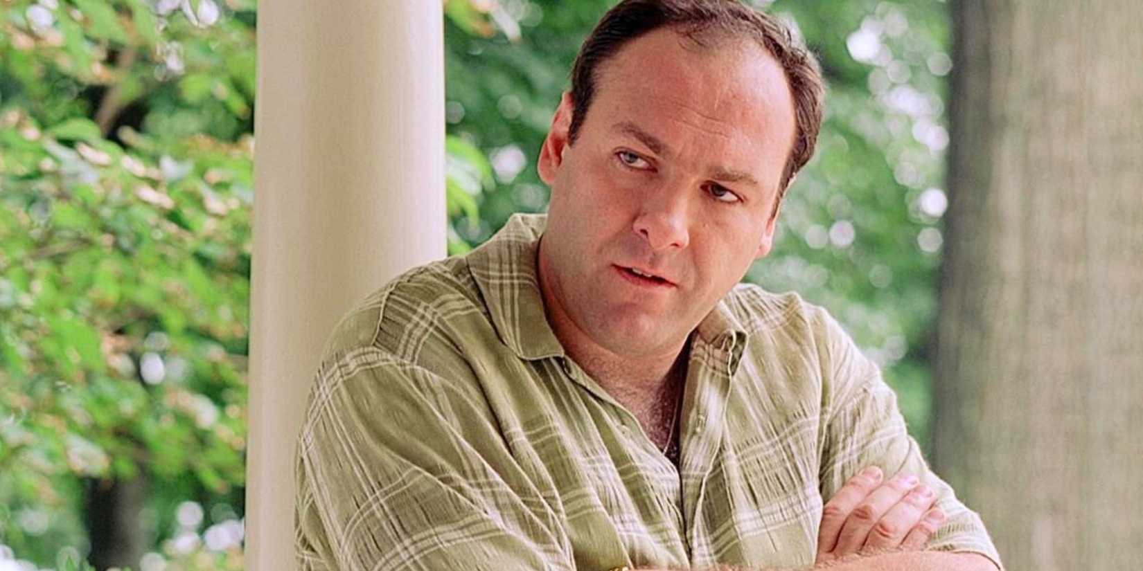 James Gandolfini as Tony Soprano in The Sopranos episode Pilot, standing with his arms crossed.