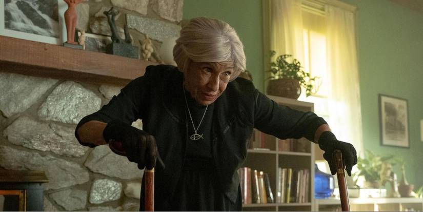 Kathryn Hunter holding two canes and staring at someone in 'The Front Room'.