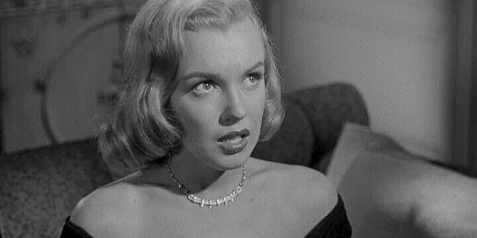 Marilyn Monroe sits looking up, worried, in The Asphalt Jungle (1950)