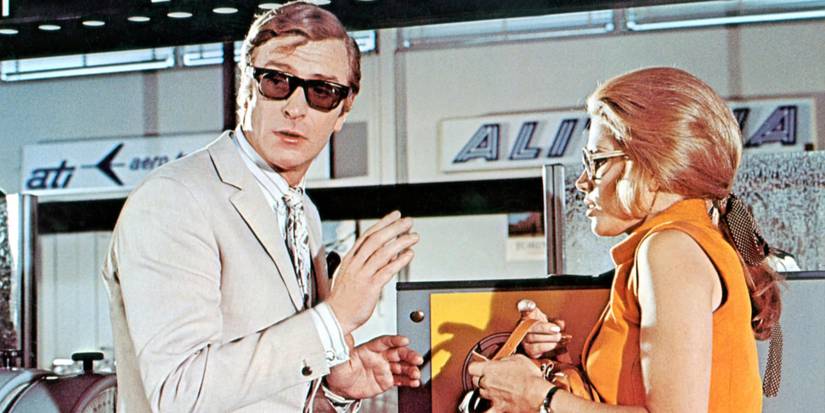 Michael Caine and Maggie Blye talk outside of an airport in 1969's The Italian Job.