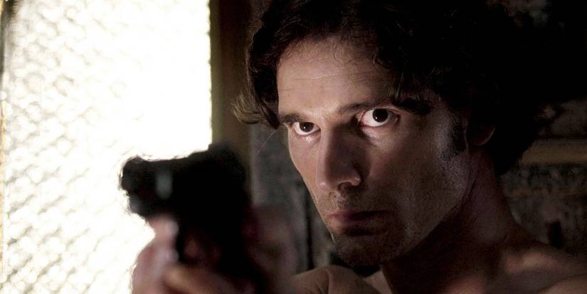 Israeli spy Avana Kaufman (Eric Bana) stands in a shadowy room aiming his pistol in 'Munich' (2005).