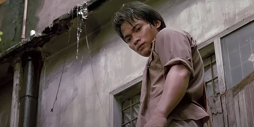 Tony Jaa looking down from a building after a chase in 'Ong-Bak'
