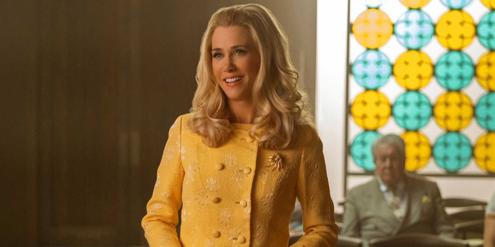 Kristen Wiig as Maxine smiling in a mustard coat in Season 1 of Palm Royale