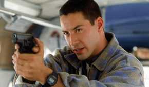 Keanu Reeves as Jack pointing a gun on a bus in Speed.
