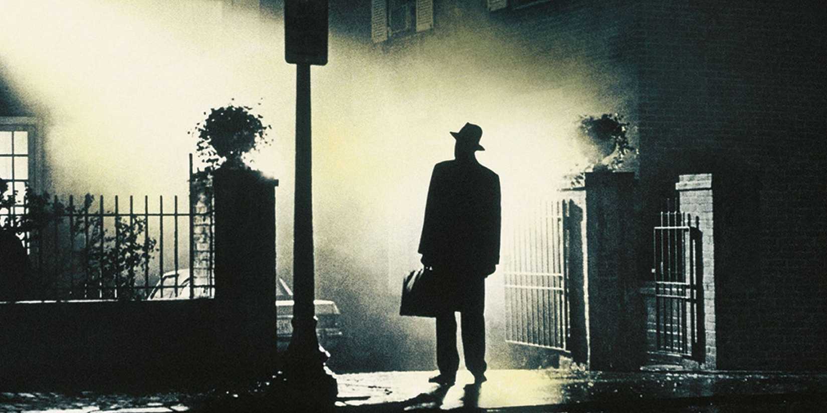 Seorang pendeta berdiri di luar rumah pada malam hari di The-Exorcist 