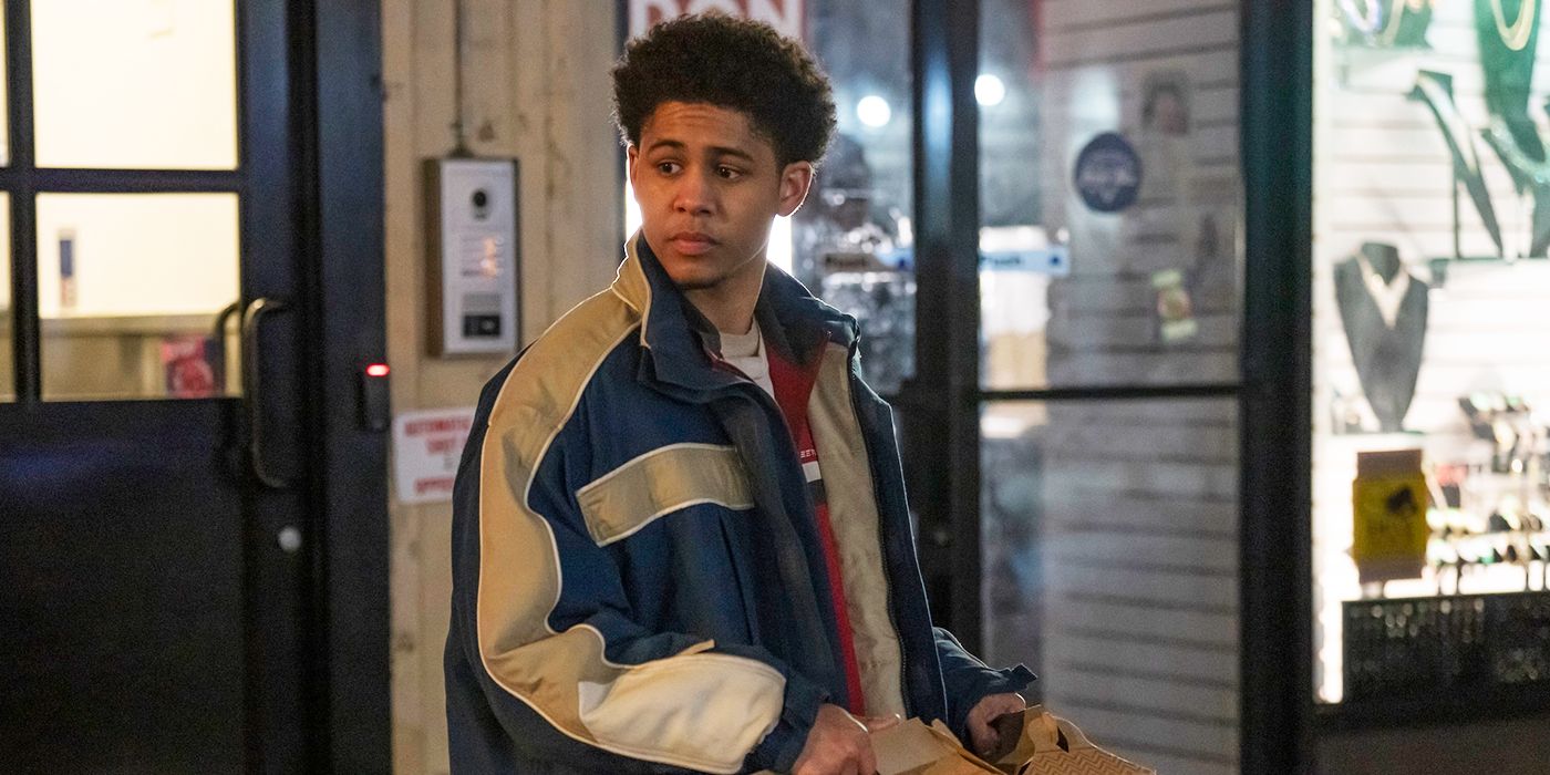 Rhenzy Feliz as Victor Aguilar standing outside in a navy blue and grey jacket in The Penguin.