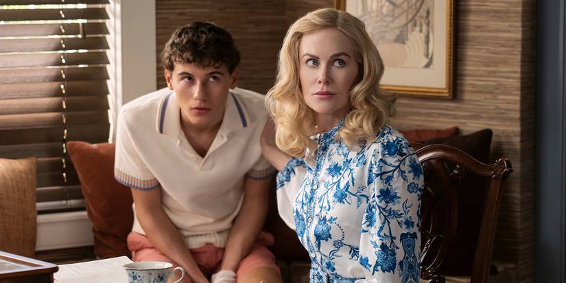 Nicole Kidman and a young man sit in a dining room, looking up, in The Perfect Couple