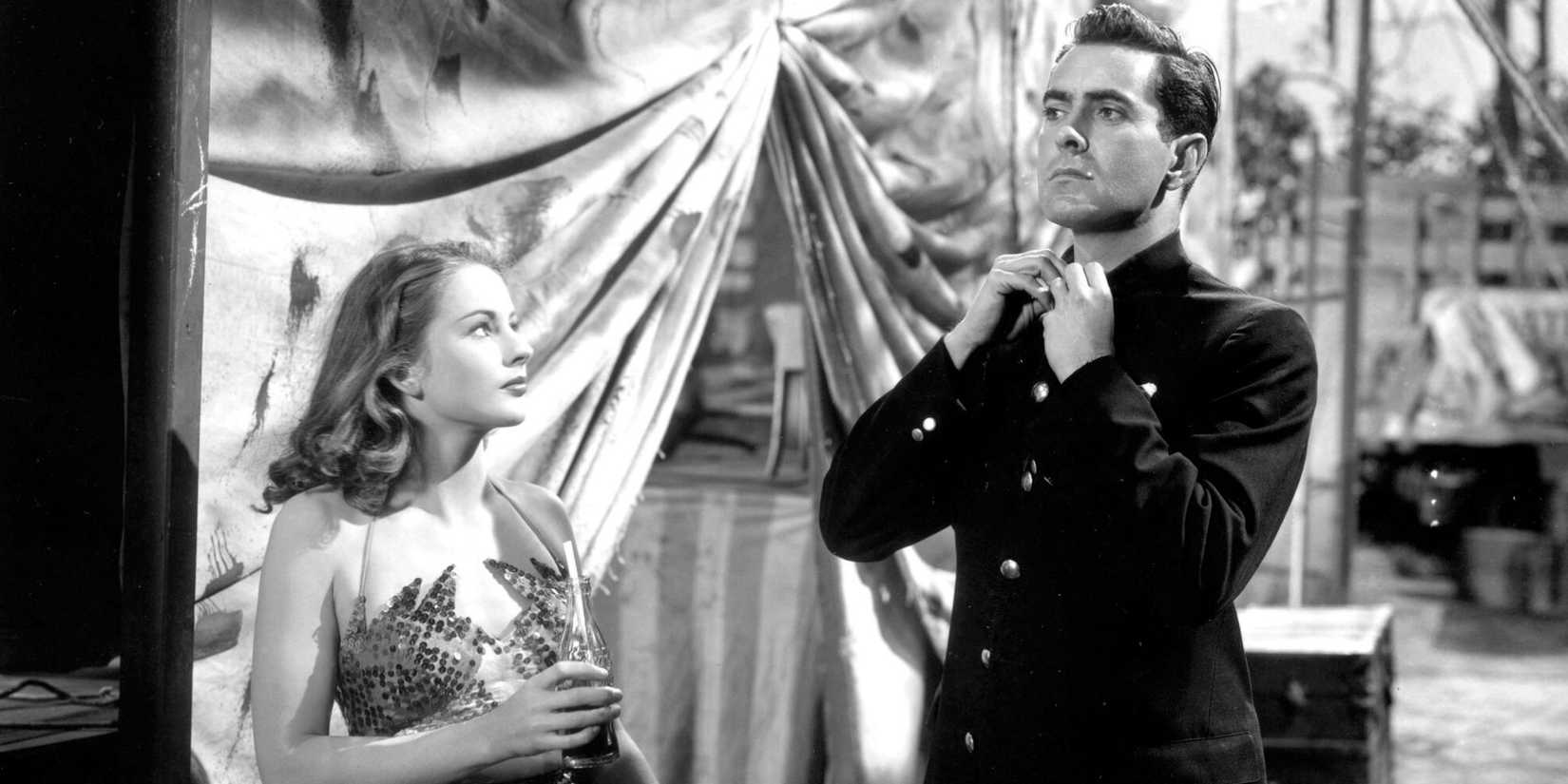 Tyrone Power straightening his collar while Coleen Gray is looking at him in Nightmare Alley (1947)