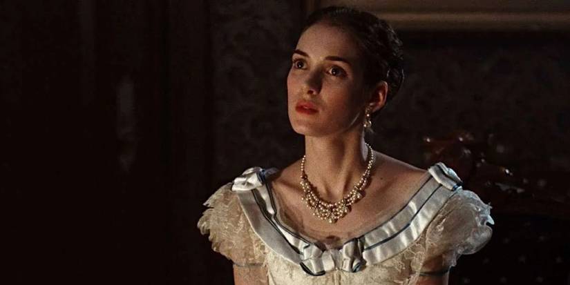 Winona Ryder as May in a period dress looking at someone off-camera in The Age of Innocence.