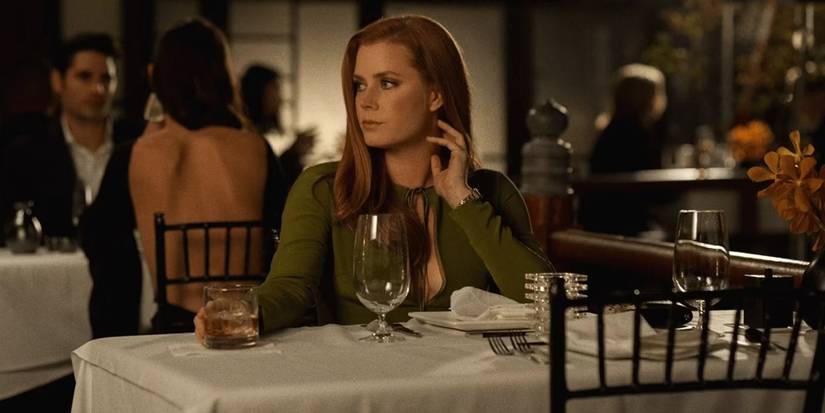 Amy Adams at a dinner table, looking right in 'Nocturnal Animals'