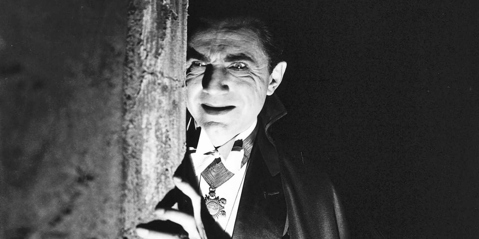 Bela Lugosi as Count Dracula peering out behind a wall in Dracula