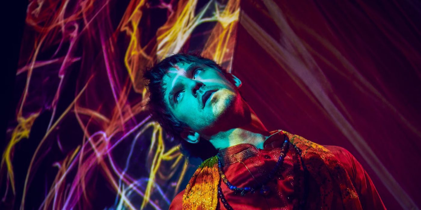 Dan Stevens as David Haller with his head tilted to the side under a beam of light in Legion.