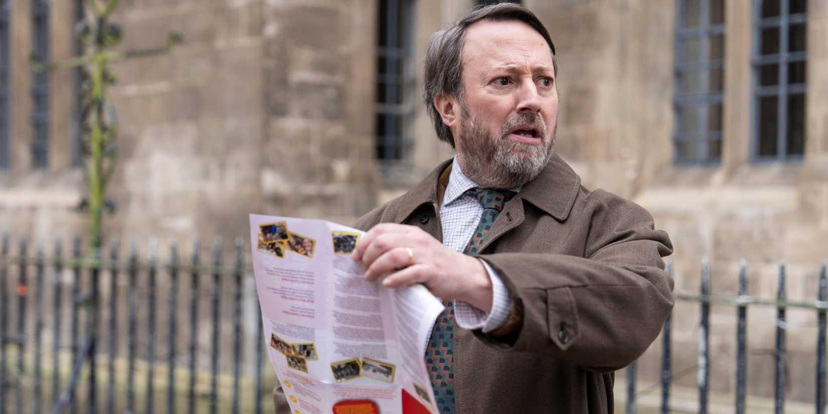 David Mitchell as the titular Ludwig holding a map and looking to the right confused in Ludwig.