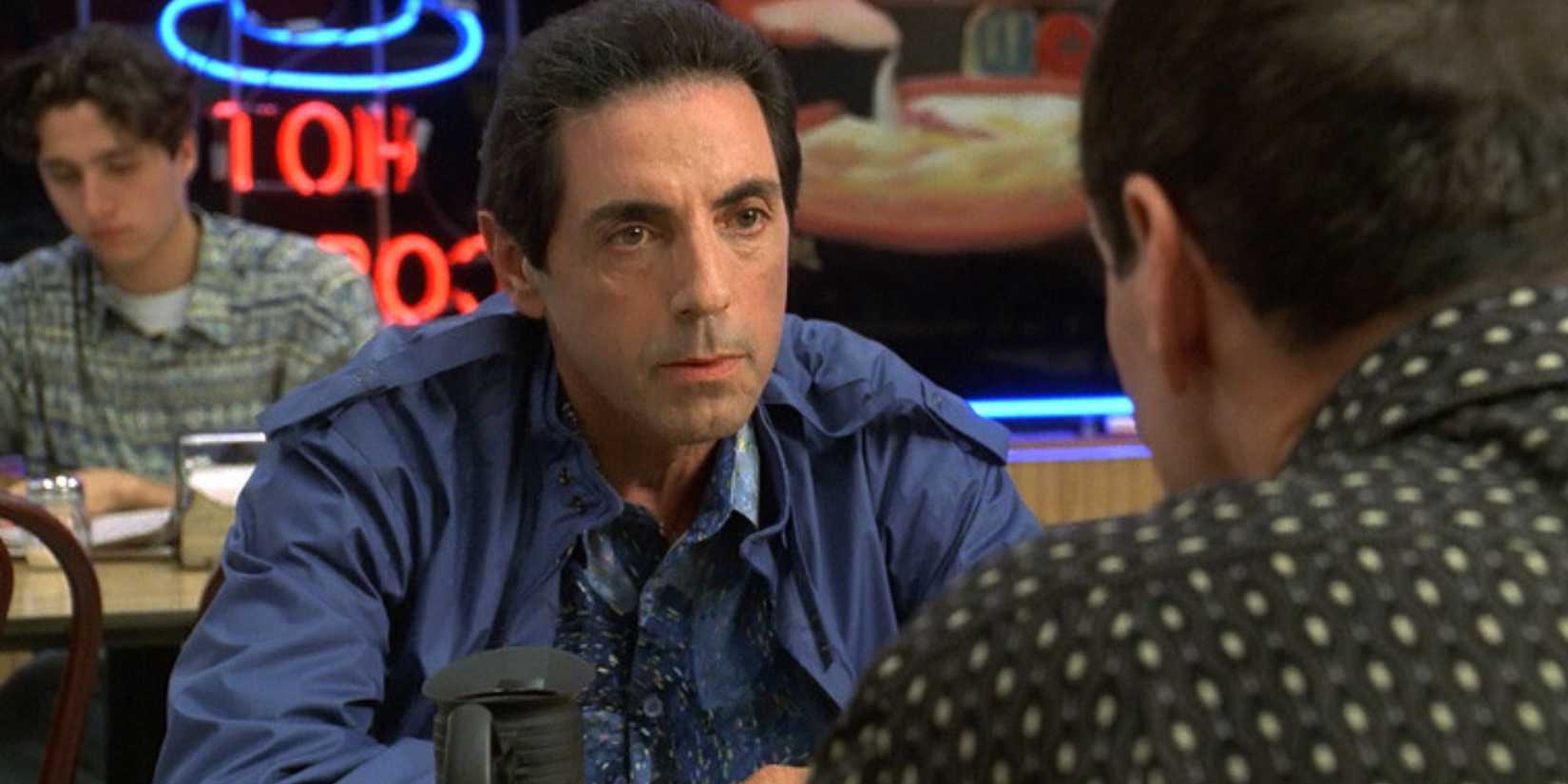 David Proval as Richie Aprile sitting at a table looking at Paul Herman as Beansie in The Sopranos
