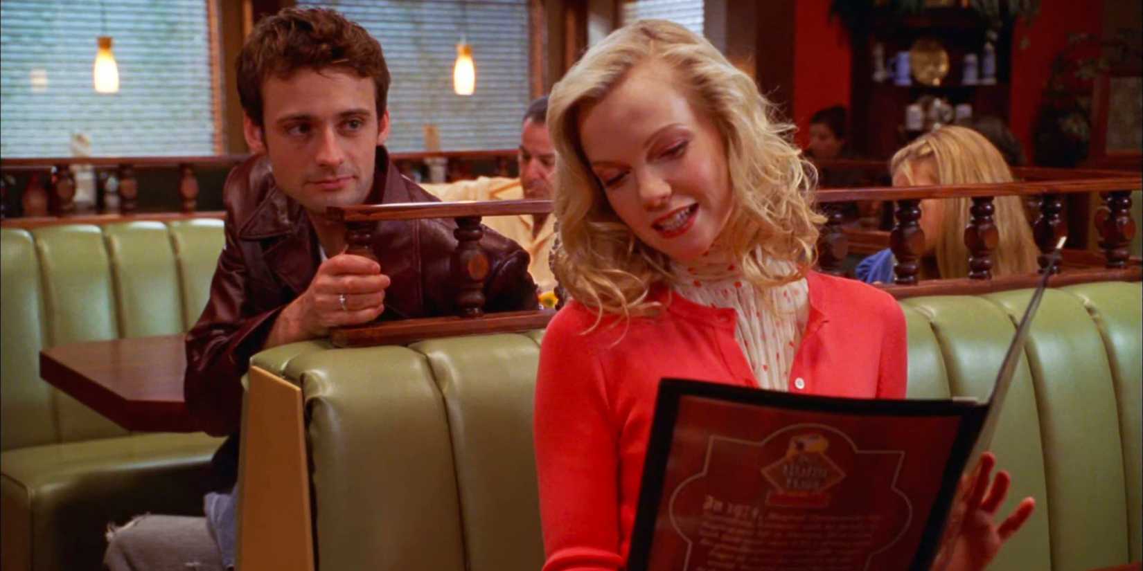 A woman showing a man a menu in a restaurant in Dead Like Me.
