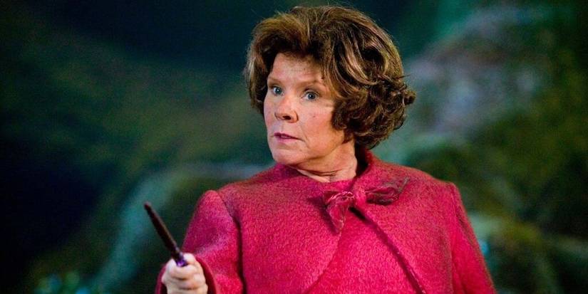 Imelda Staunton as Dolores Umbridge holds a wand and looks at someone off-screen in the Harry Potter movies
