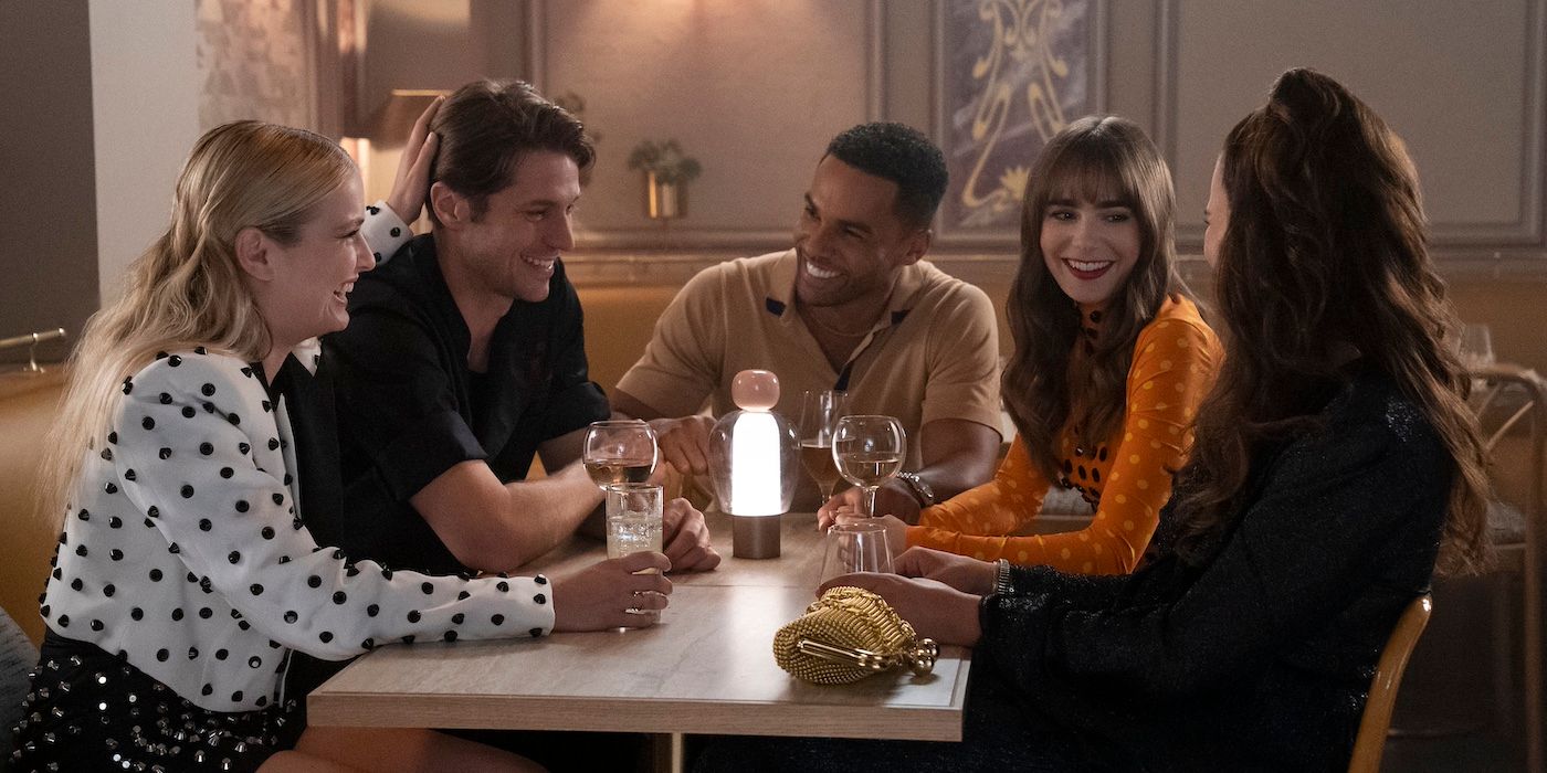 The main cast of Emily in Paris laughing at a restaurant