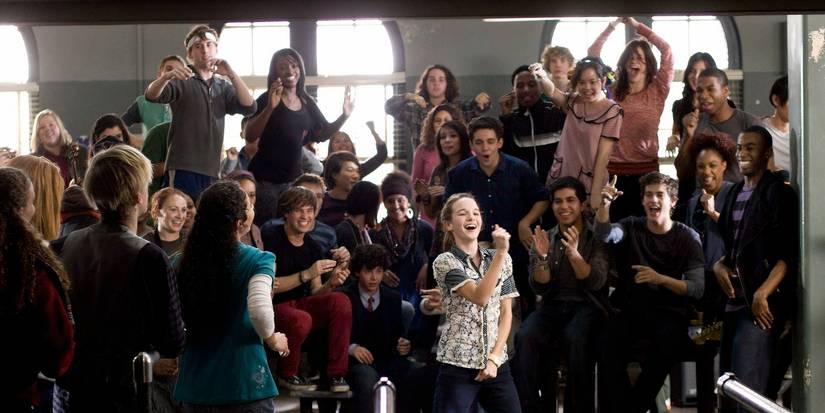 A crowd looking at a girl as she performs in Fame