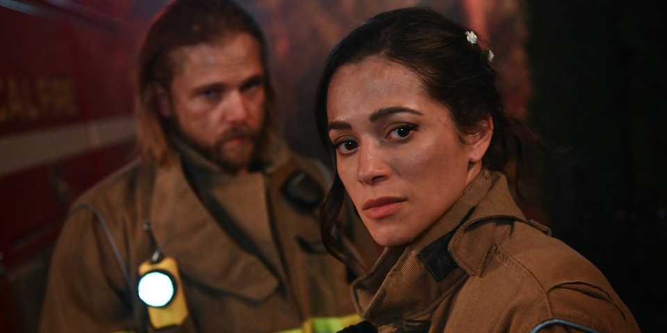 Stephanie Arcila as Gabriela Perez and Max Thieriot as Bode Leone in gear at a fire in 'Fire Country.'