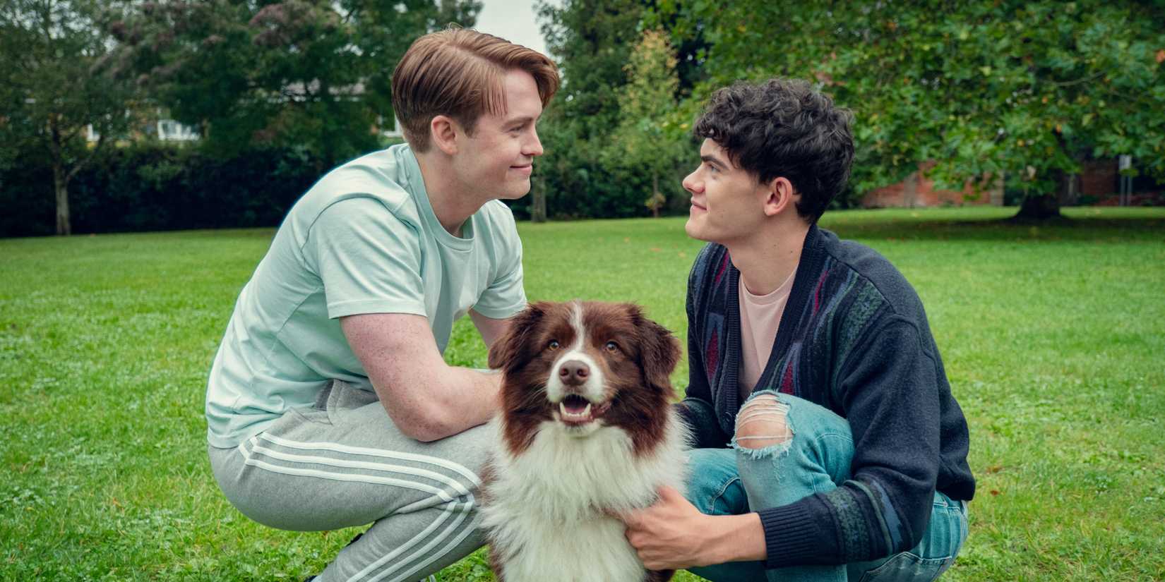 Kit Connor as Nick and Joe Locke as Charlie with a dog in the park in Heartstopper S3E7.