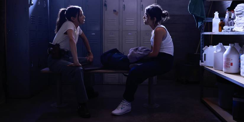 Lala Dominguez (Mariel Molino) and Vera Strickland (Diany Rodriguez) sitting on a bench in the NIS locker room, seen in NCIS: Origins