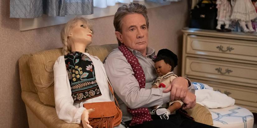 Oliver (Martin Short) sitting next to the Loretta doll and holding a baby doll in his arms in 'Only Murders in the Building.'