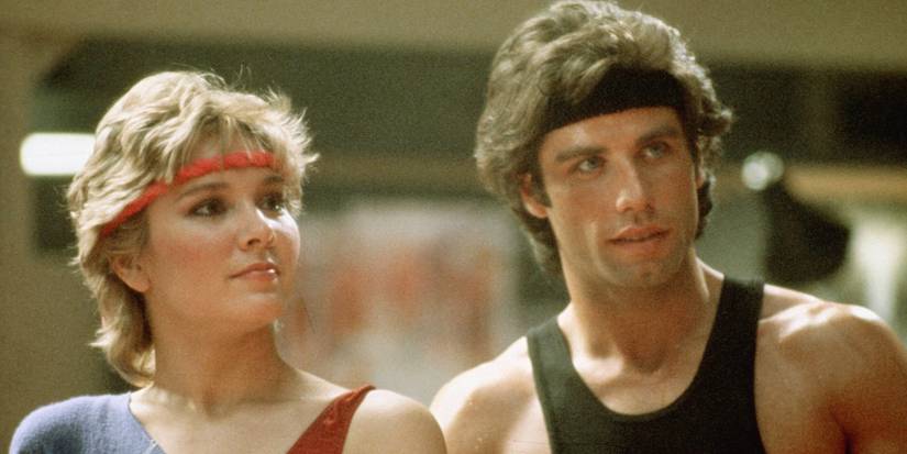 John Travolta's Tony standing with Cynthia Rhodes' Jackie in Staying Alive