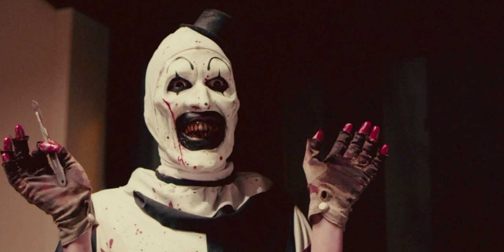 Art le clown levant les mains tout en portant des gants ensanglantés dans Terrifier