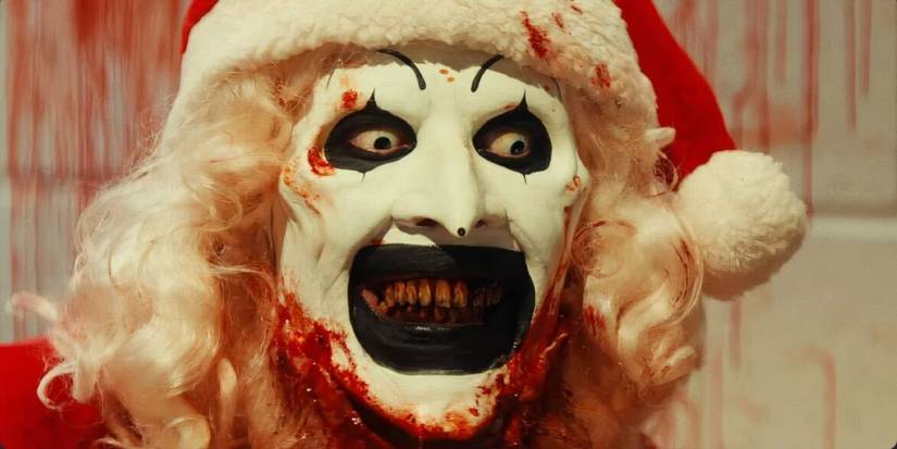 Art the Clown in a bloody Santa suit looking into Mia's eyes in Terrifier 3. 