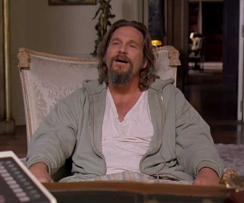 The Dude (Jeff Bridges) sits in a table in a lavish office in 'The Big Lebowski' (1998).