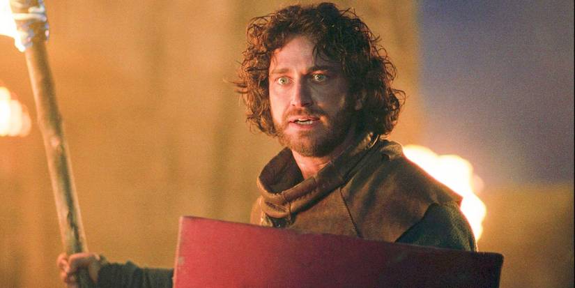Gerard Butler as Andre Marek in knight gear holding a torch in Timeline