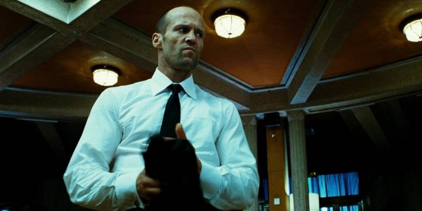 Jason Statham in a suit, wrapping cloth around his fist, in Transporter 3
