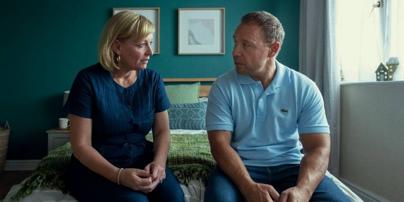 Christine Tremarco as Manda Miller and Stephen Graham as Eddie Miller sit on a bed in 'Adolescence'.