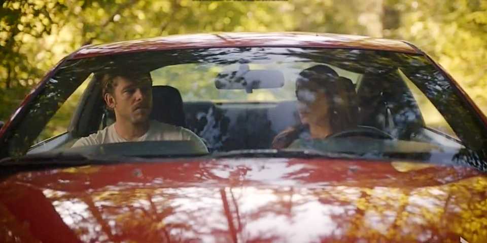 Bode Leona and Gabriela Perez sitting in a red car together and both looking solemn in Fire Country Season 3.