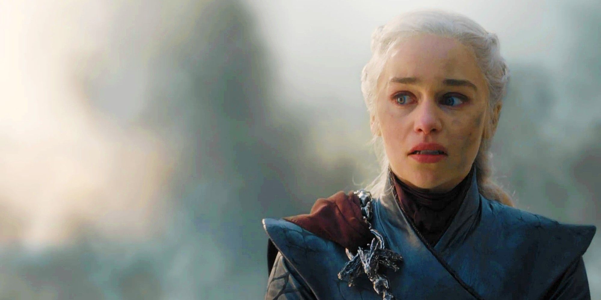 Daenerys Targaryen with a smudged face looks tense with smoke in the background in Game of Thrones Season 8.